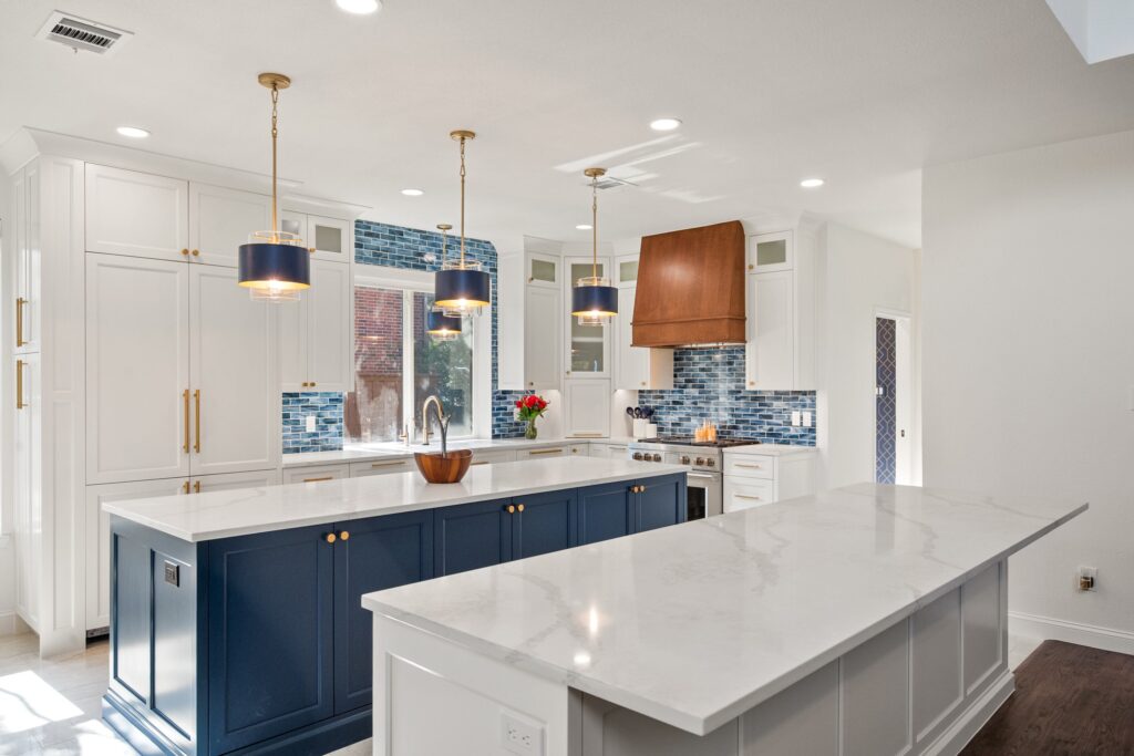 Dual-island kitchen with navy cabinets and a blue tile backsplash
