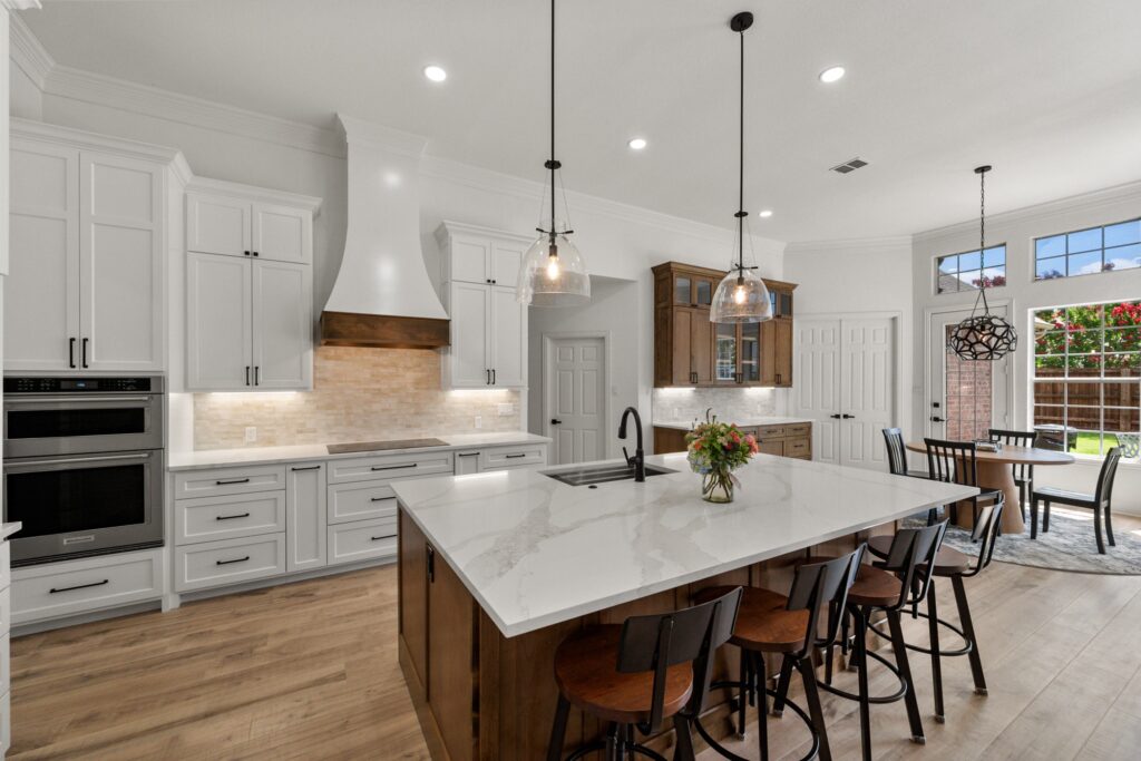 White kitchen with a walnut island and plaster hood