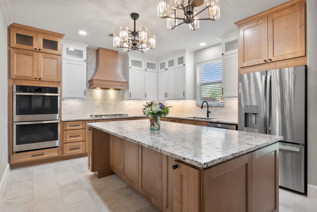 Kitchen with oak cabinets, a wood hood, and a granite island