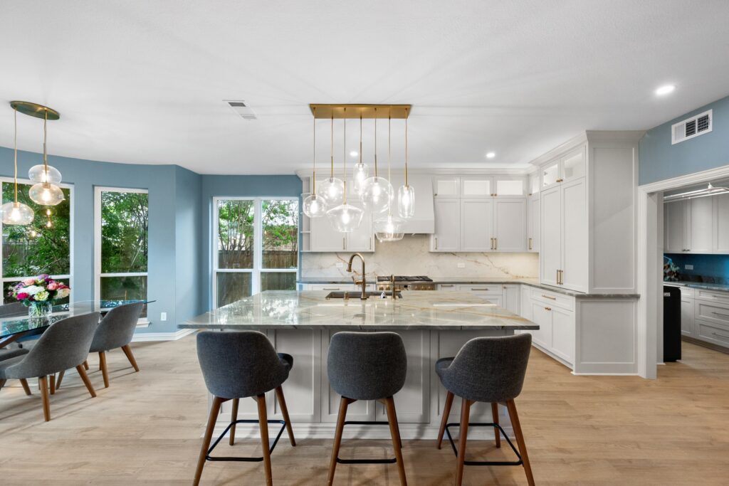 White kitchen with blue walls and a glass globe chandelier