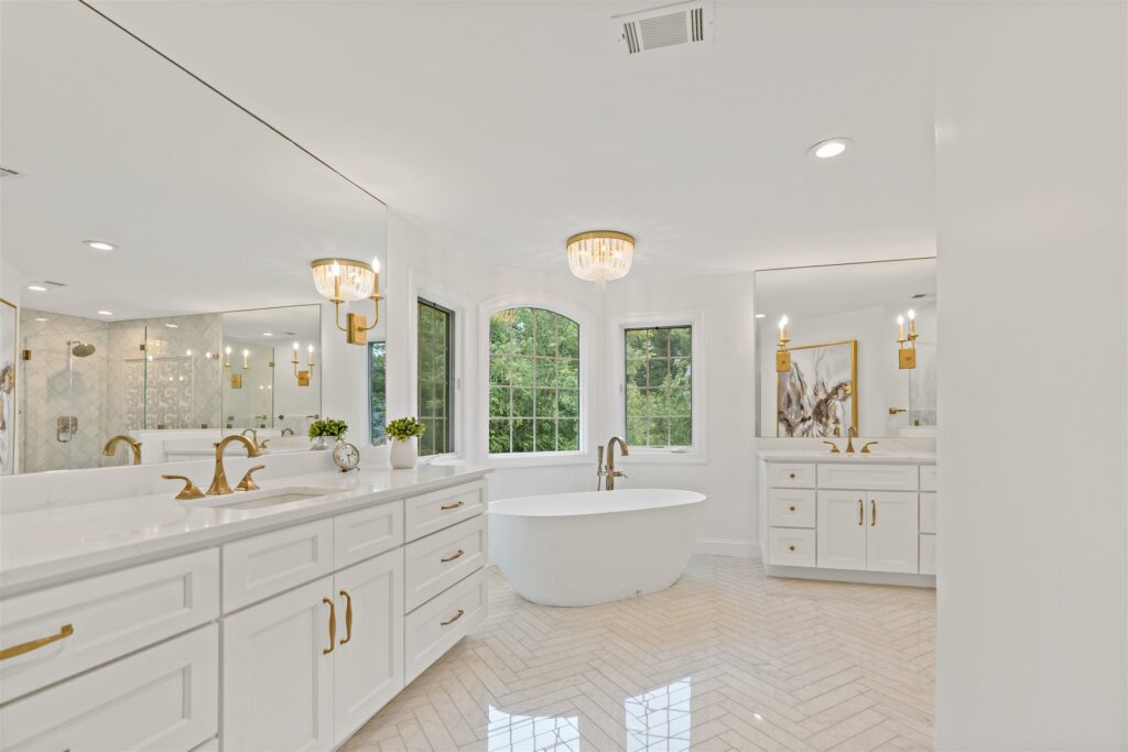 Primary bathroom with dual vanities and a freestanding tub